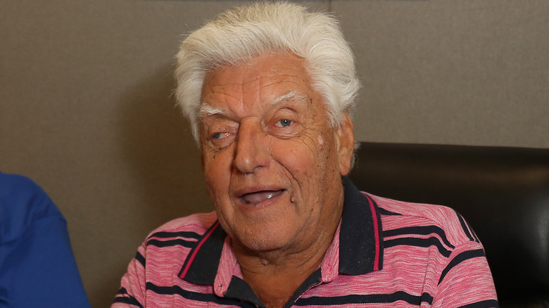 David Prowse sits and smiles in a pink polo shirt