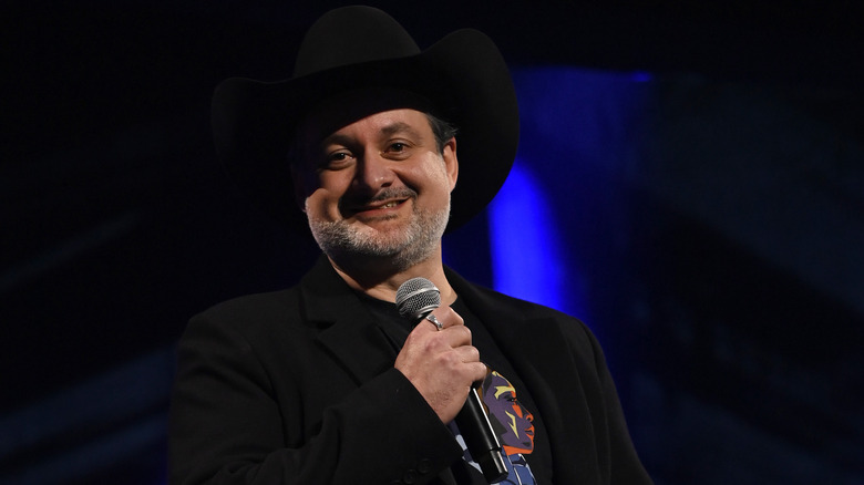 Dave Filoni holds a microphone