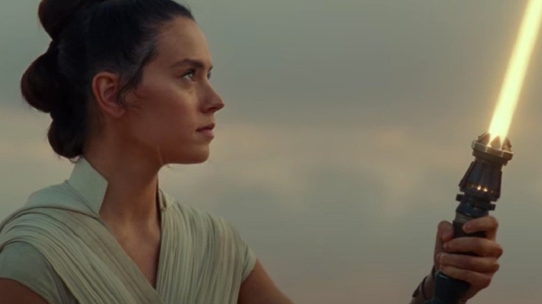 Rey looking at her lightsaber