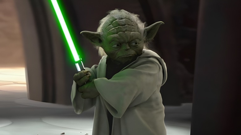 Yoda holding lightsaber