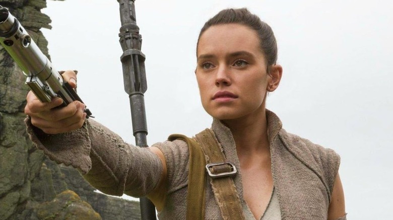 Rey holding a lightsaber