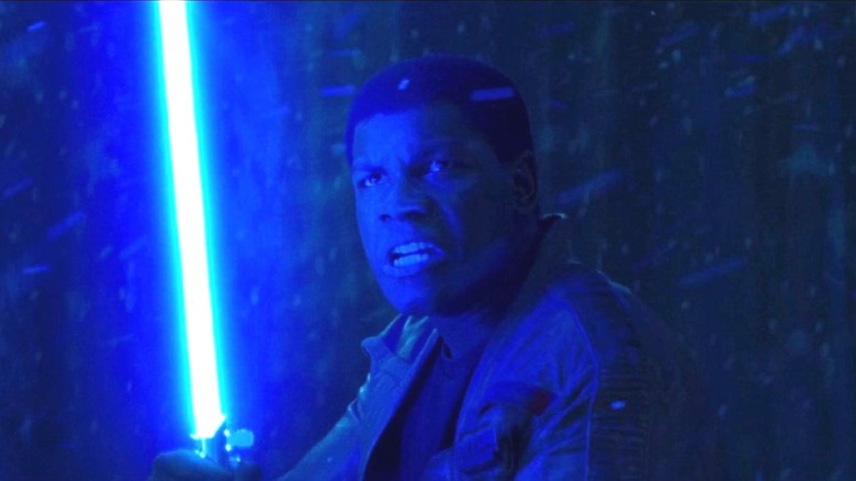 Finn holding a lightsaber