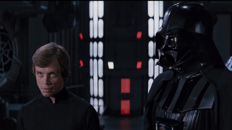 Luke Skywalker standing beside Darth Vader 