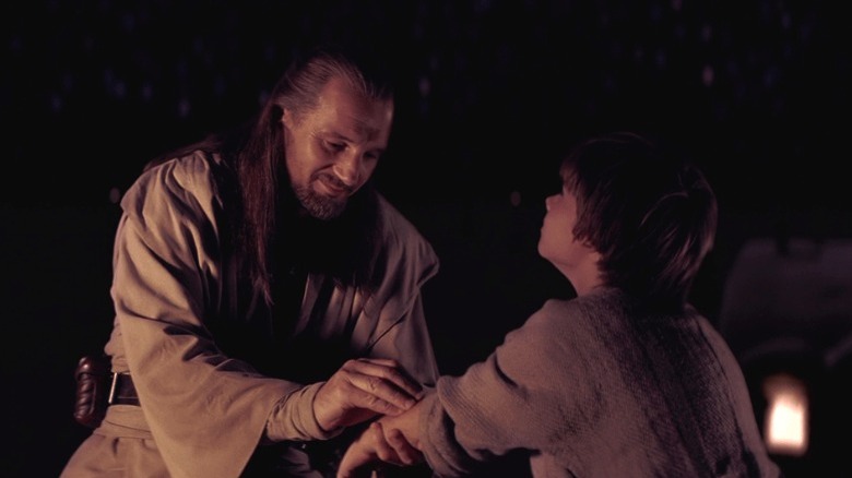 Qui-Gon Jinn holding Anakin Skywalker's arm