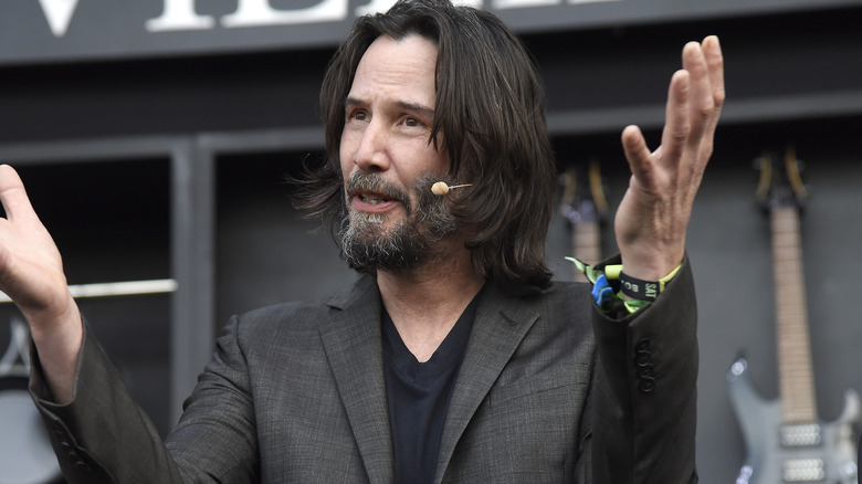 Keanu Reeves speaking into microphone