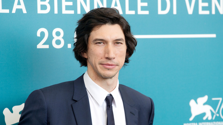 Adam Driver smiling wearing suit