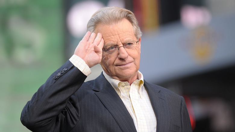 Jerry Springer saluting wearing suit