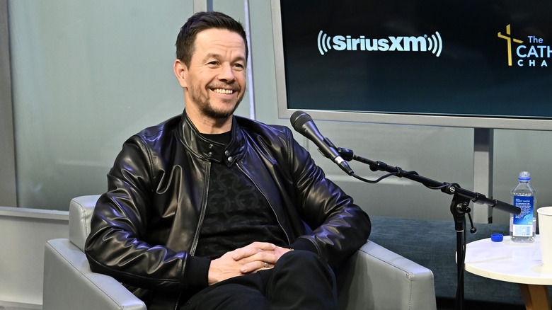 Mark Wahlberg smiling while sitting in a chair