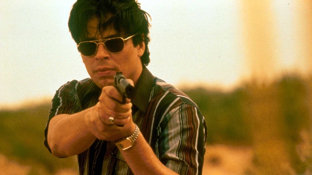 Benicio Del Toro aiming gun