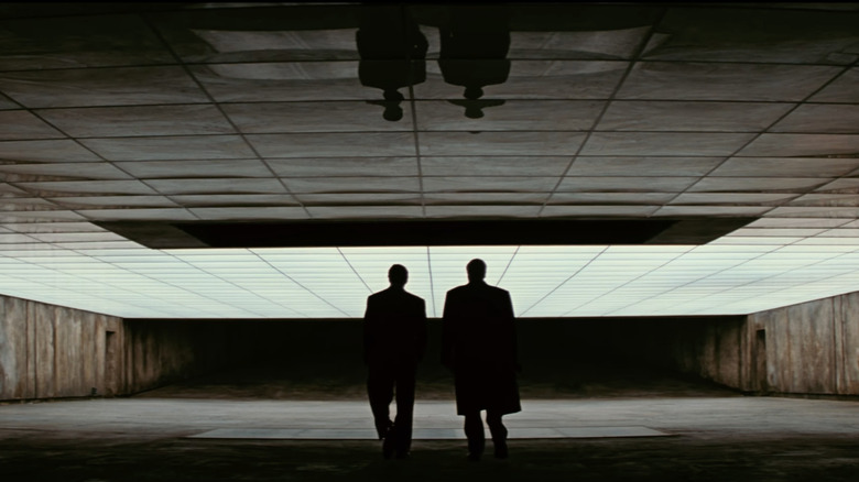 Bruce Wayne and Alfred walk through the Batcave 