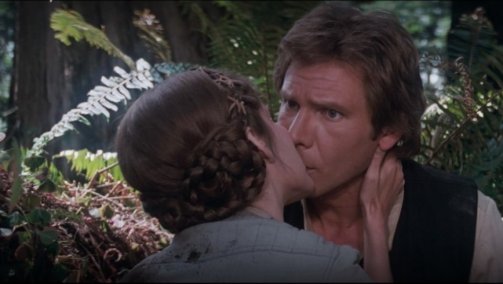 Carrie Fisher as Princess Leia kissing a confused Harrison Ford as Han Solo on Endor in Star Wars: Return of the Jedi