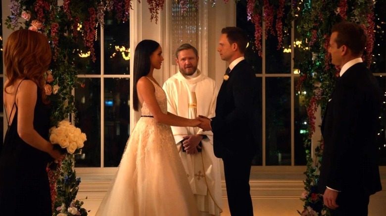 Rachel and Mike hold hands at their wedding