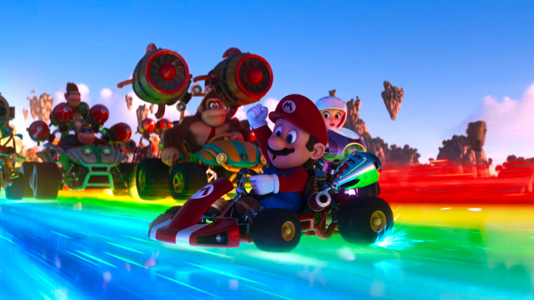 Mario drifts on a mario kart on rainbow road, followed by Donkey Kong, Peach, and various other drivers