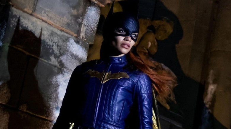 Batgirl stands against wall