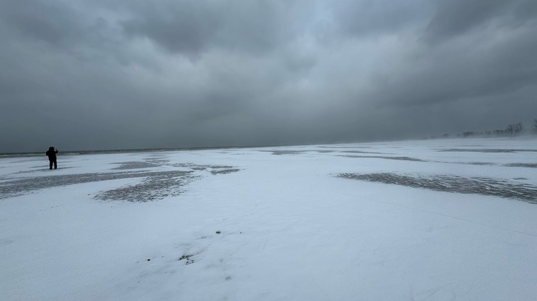 A filmmaker stands on a frozen location