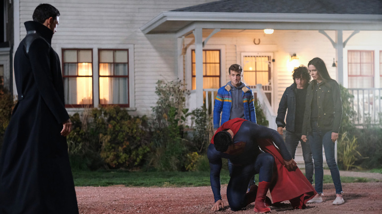 Superman kneeling to as family watches