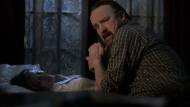 Bobby Singer holding dying Karen's hand