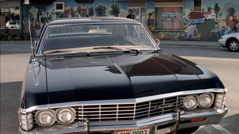 A 1967 Chevy Impala sits in front of a mural on Supernatural