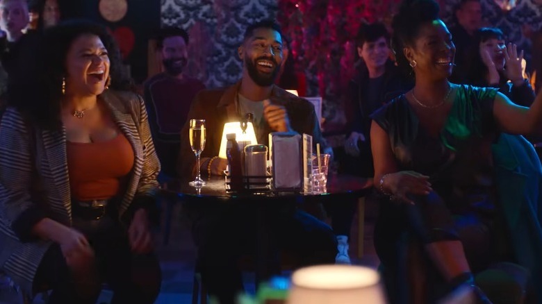 Mavis, Khalil, and Marley laughing around a bar table