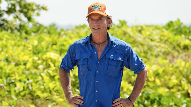 Jeff Probst blue shirt orange cap hands on hips