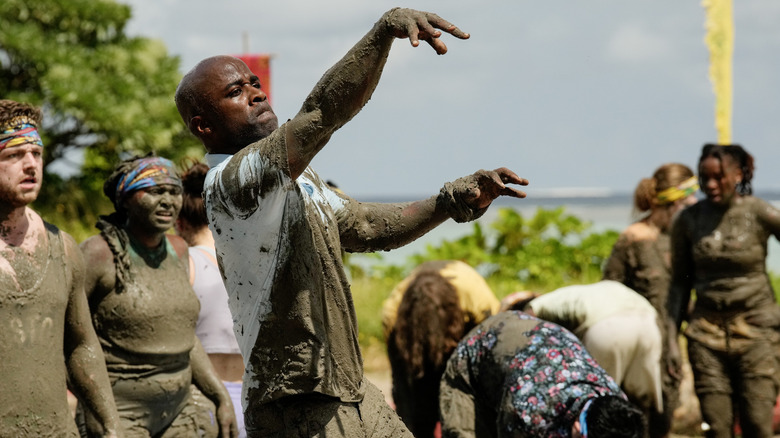 Bruce tossing ball covered in mud