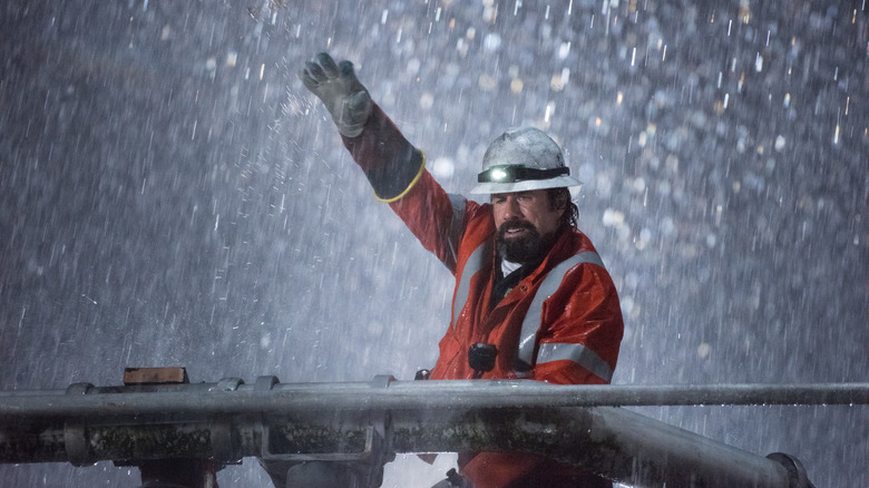 Beau Ginner waving in the rain while working on electrical pole