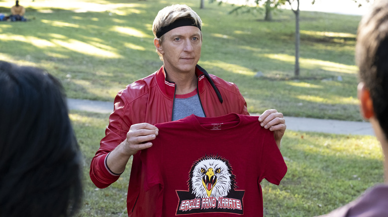 William Zabka holding a shirt