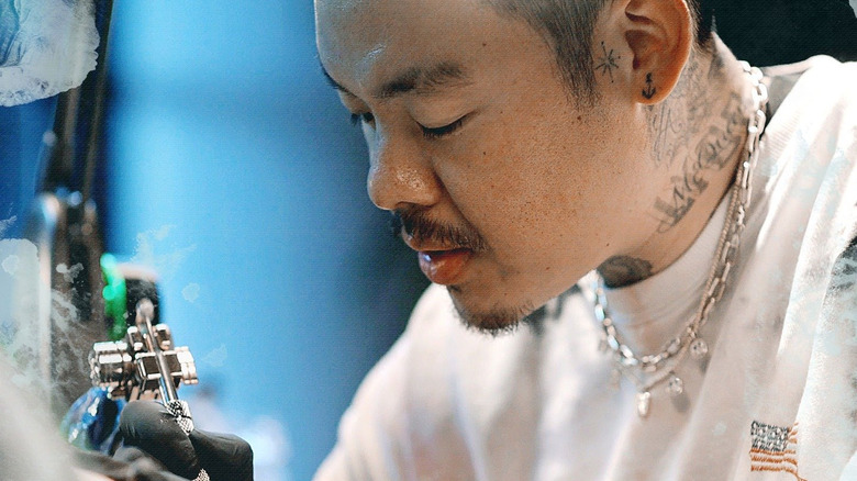 Dr. Woo tattooing a client