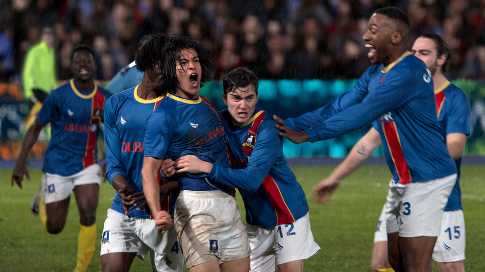 football (soccer) team celebrating together in rain