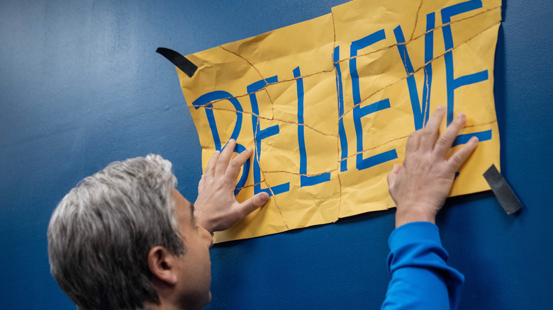 Nate holding the believe sign