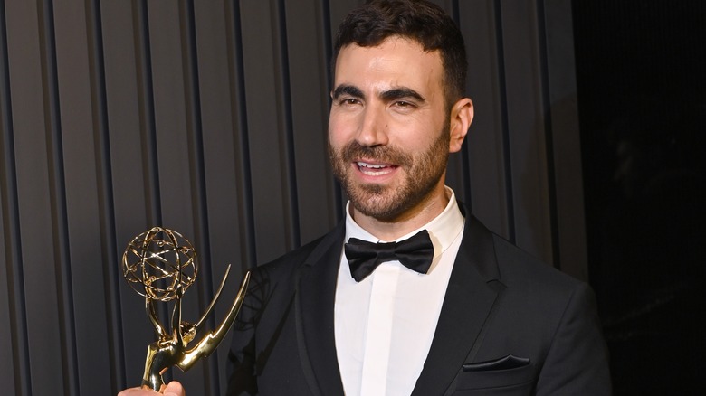 Brett Goldstein wearing tuxedo holding an Emmy