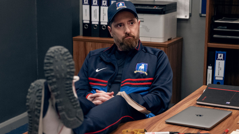 Coach Beard sits with feet on desk