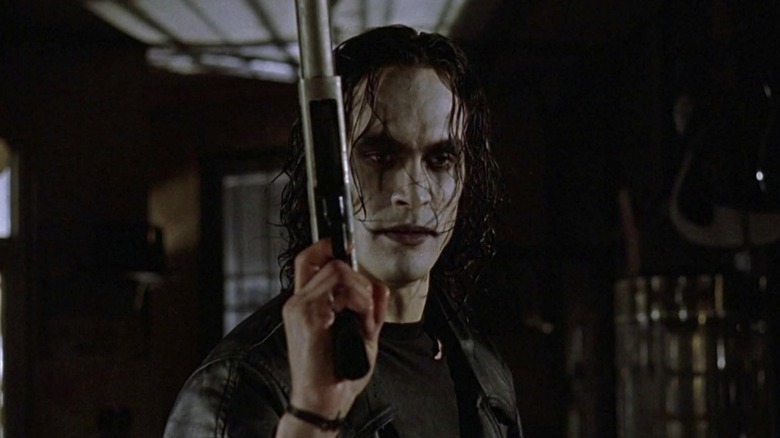 Eric Draven/The Crow holds up a weapon in "The Crow" (1994)