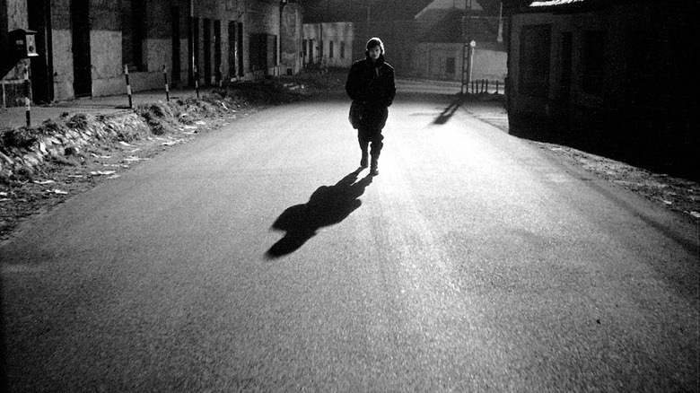 Janos walking down the street at night in Werckmeister Harmonies