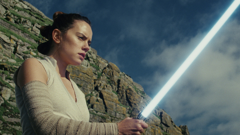 Rey wielding a blue lightsaber