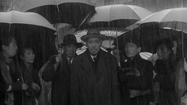 Kanji Watanabe with a crowd in the rain in "Ikiru"