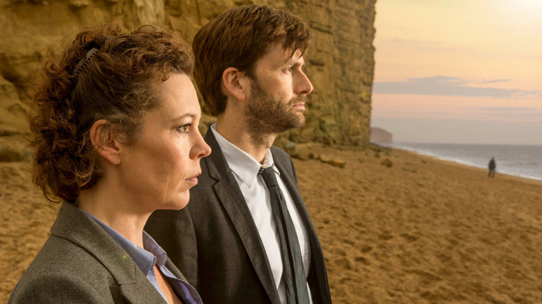 Ellie Miller and Alec Hardy on a beach staring