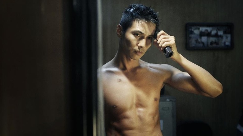 Tae-sik stands in front of a mirror shaving the side of his head in "The Man from Nowhere" (2010)