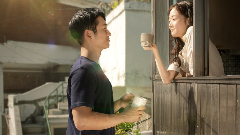 Hyun-woo stands at the coffee shop window where Mi-soo leans out and smiles at him in "Tune in for Love (2019)