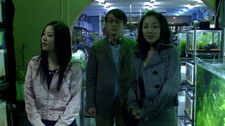 A girl is shown around a fish shop