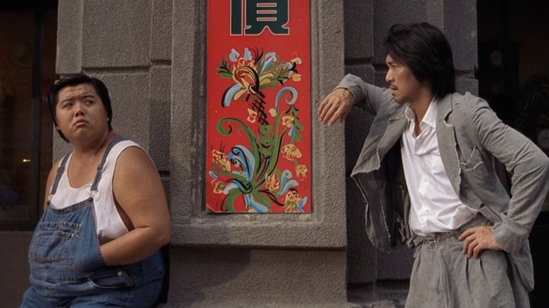 Sing talking to Bone while leaning against a wall in "Kung Fu Hustle"