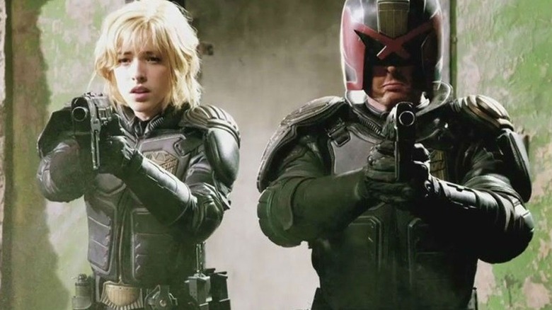 Dredd and Cassandra pointing guns