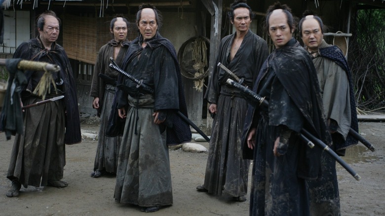 A group of samurai warriors standing together wearing black Kimonos in 13 Assassins