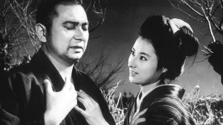 The blind samurai Zaitoichi standing before Otane in The Tale of Zatoichi