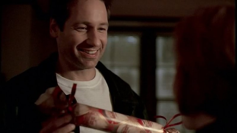 Mulder grinning and holding gift