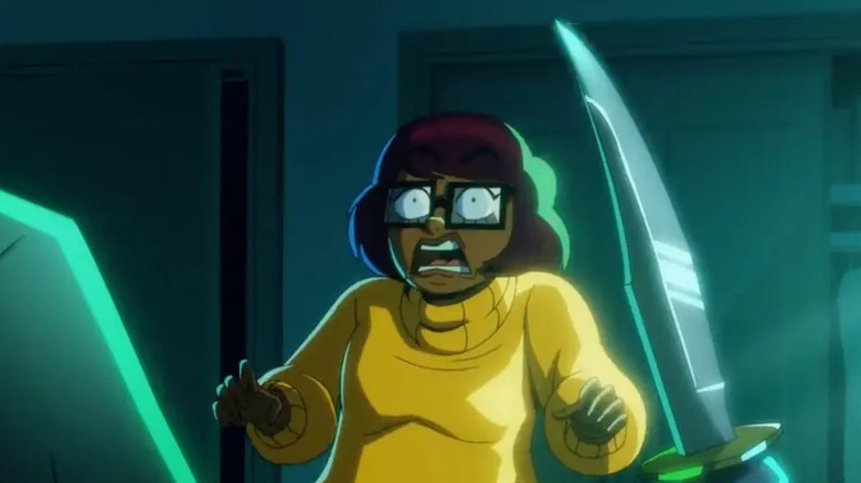 Velma looking terrified as she is confronted by someone holding a knife on Velma