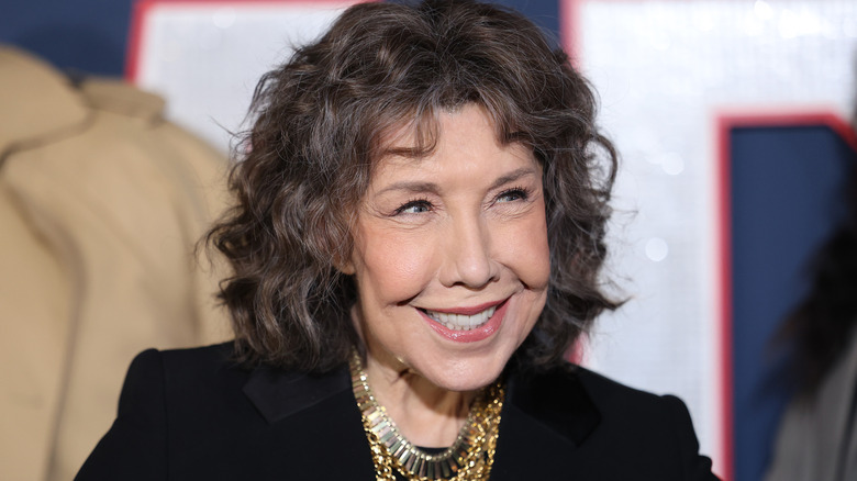 Lily Tomlin smiling in black jacket