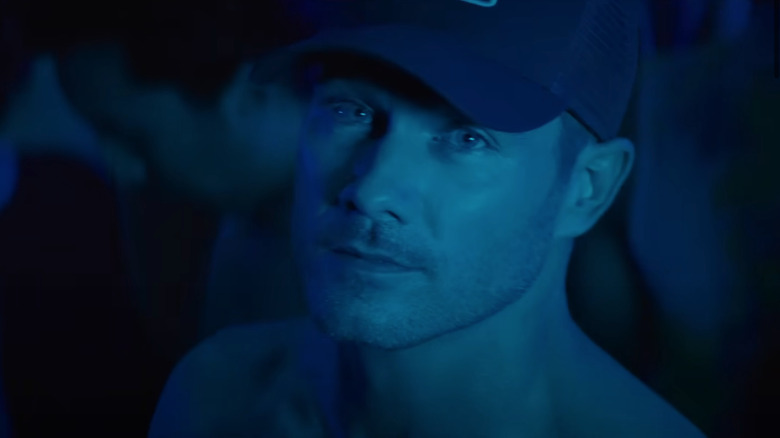 Aaron standing in a club in blue lighting