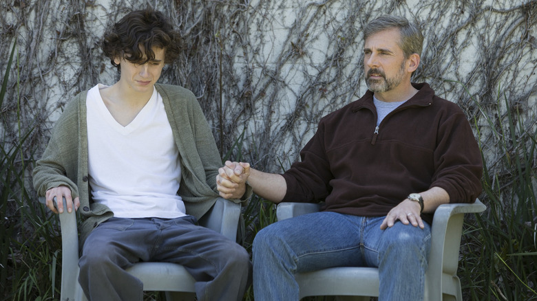 Timothee Chalamet and Steve Carell hold hands in chairs