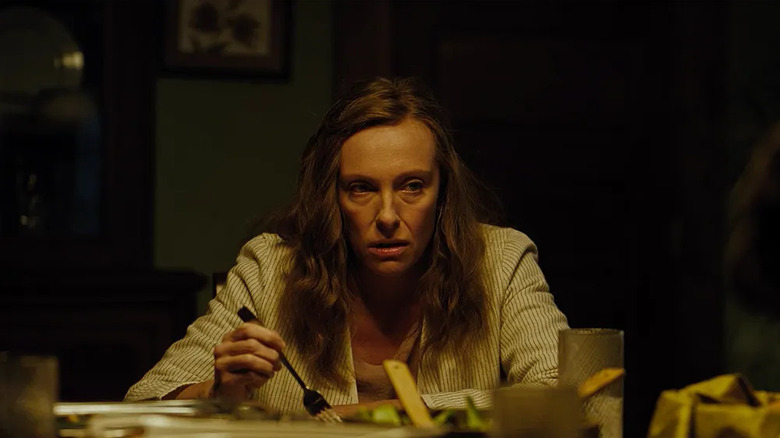 Annie angrily eating dinner and scowling in Hereditary